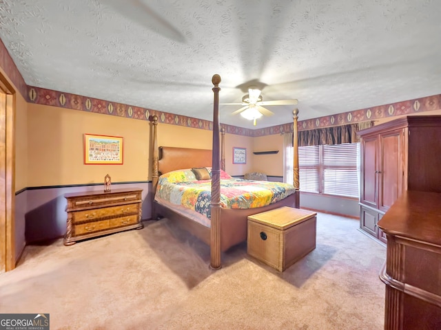 unfurnished bedroom with ceiling fan, light carpet, and a textured ceiling