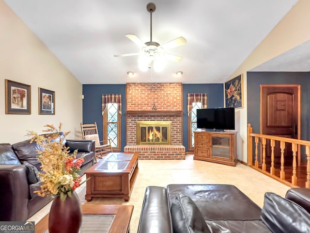 living room with ceiling fan, vaulted ceiling, and a brick fireplace