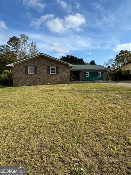 single story home with a front lawn