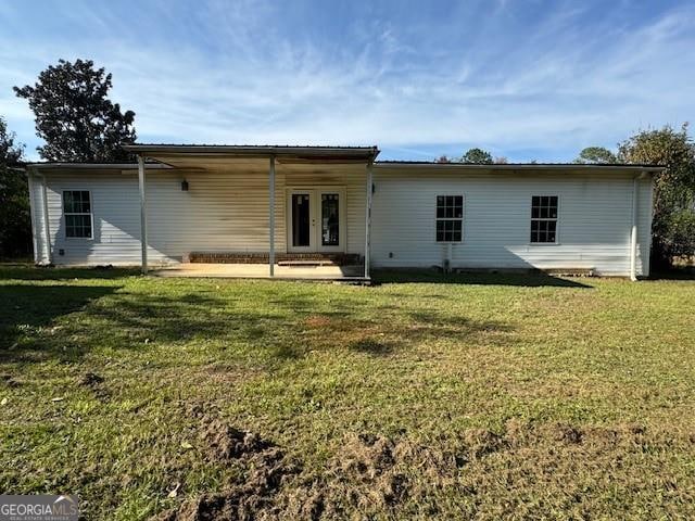 back of house featuring a yard and french doors