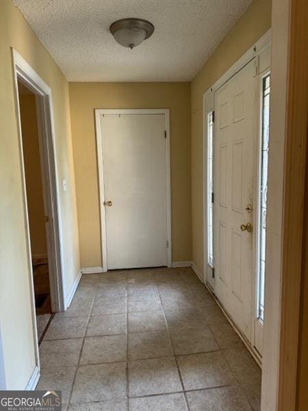 foyer entrance with a textured ceiling