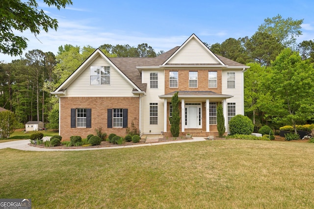 view of front of home with brick siding, a shingled roof, and a front yard