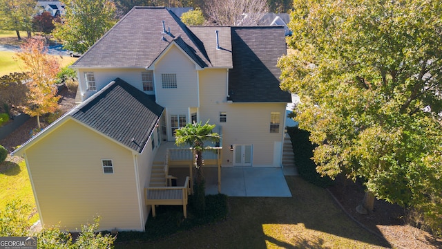 rear view of property with french doors, a patio, and a lawn