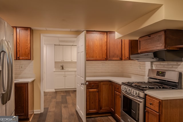 kitchen with backsplash, sink, dark wood-type flooring, and appliances with stainless steel finishes