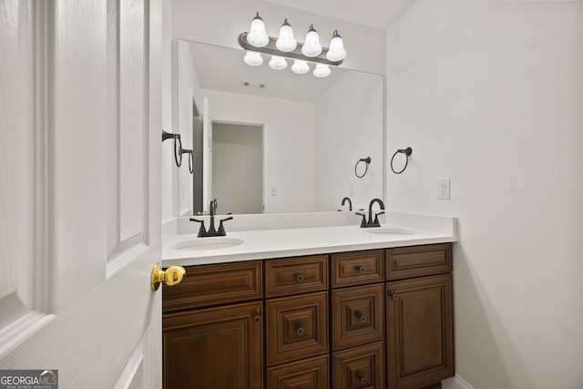 bathroom with double vanity, visible vents, and a sink