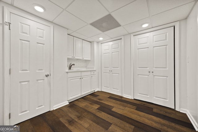 interior space featuring recessed lighting, baseboards, dark wood finished floors, and a sink
