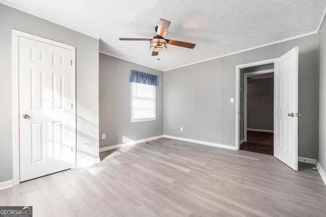 unfurnished bedroom featuring a textured ceiling, light hardwood / wood-style floors, ceiling fan, and crown molding