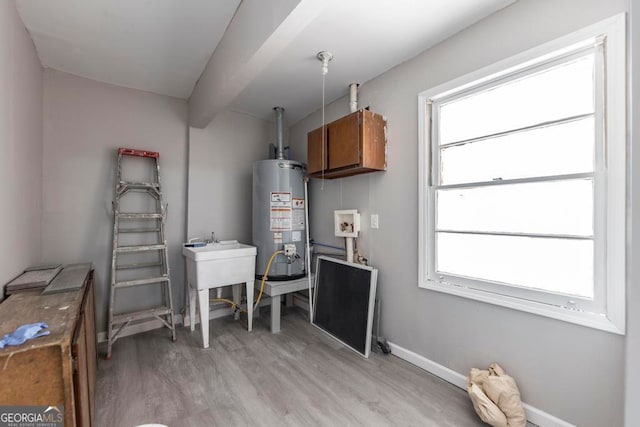 utility room with gas water heater and sink