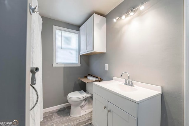 bathroom featuring toilet, vanity, and hardwood / wood-style flooring