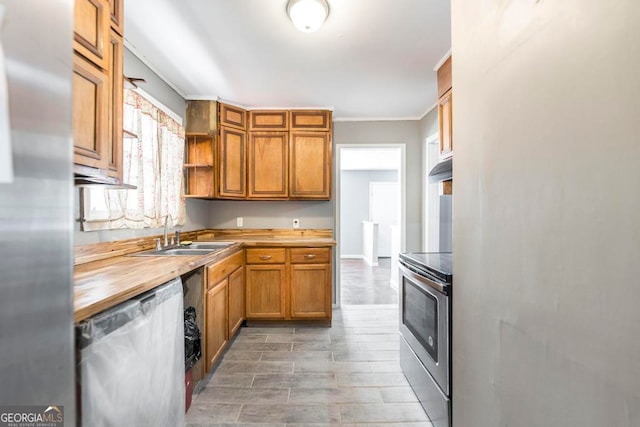 kitchen featuring wood counters, appliances with stainless steel finishes, ornamental molding, sink, and hardwood / wood-style flooring