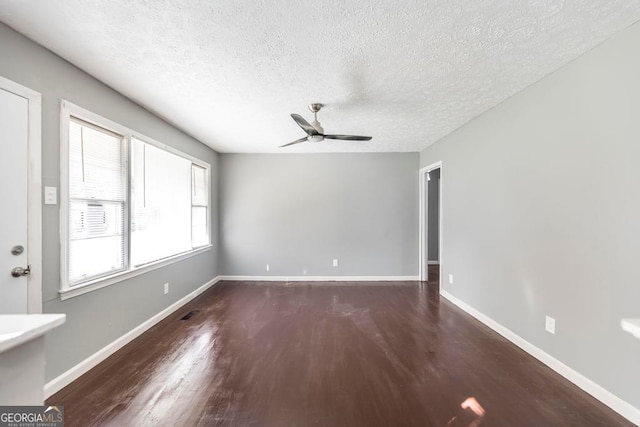 spare room featuring a textured ceiling, ceiling fan, and dark wood-type flooring