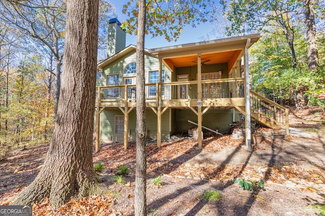 rear view of property with ceiling fan and a wooden deck