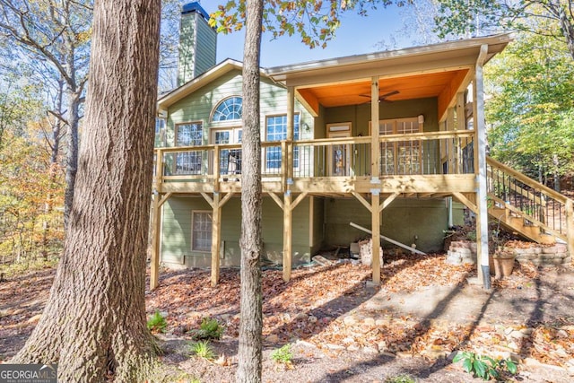 rear view of property featuring ceiling fan and a deck