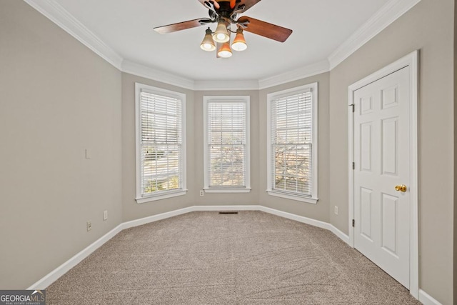 carpeted spare room featuring ceiling fan and ornamental molding