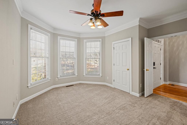 unfurnished bedroom with crown molding, ceiling fan, and light colored carpet