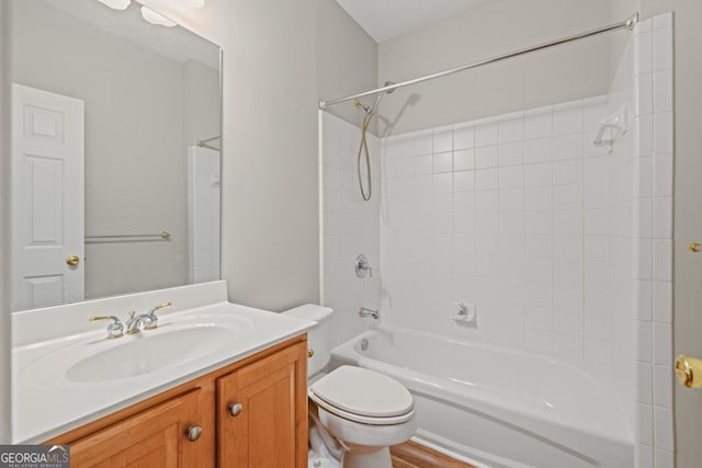 full bathroom with vanity, hardwood / wood-style flooring, toilet, and tiled shower / bath combo