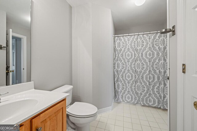 bathroom featuring toilet, vanity, tile patterned floors, and walk in shower