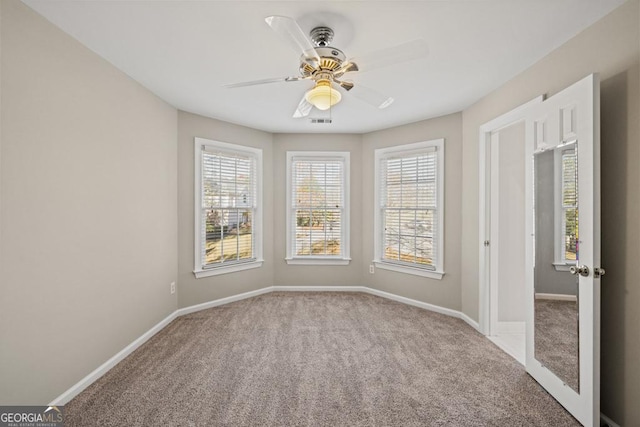 carpeted empty room with plenty of natural light and ceiling fan