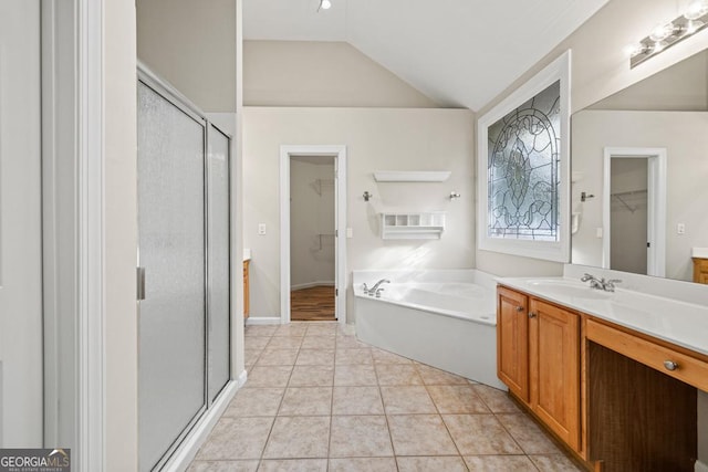 bathroom with tile patterned floors, vanity, separate shower and tub, and vaulted ceiling