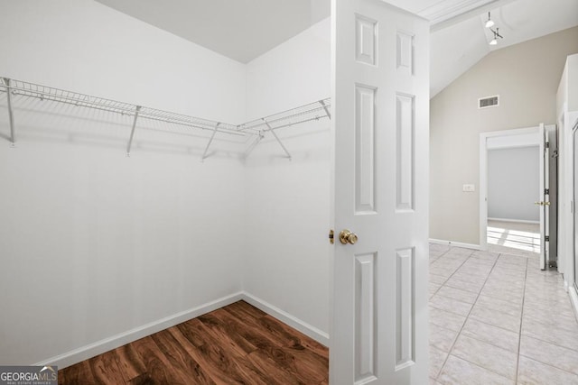 walk in closet featuring hardwood / wood-style flooring and vaulted ceiling