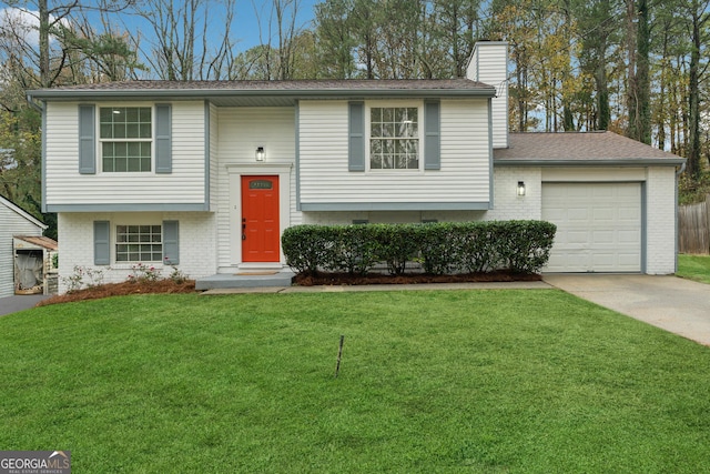 raised ranch featuring a garage and a front lawn