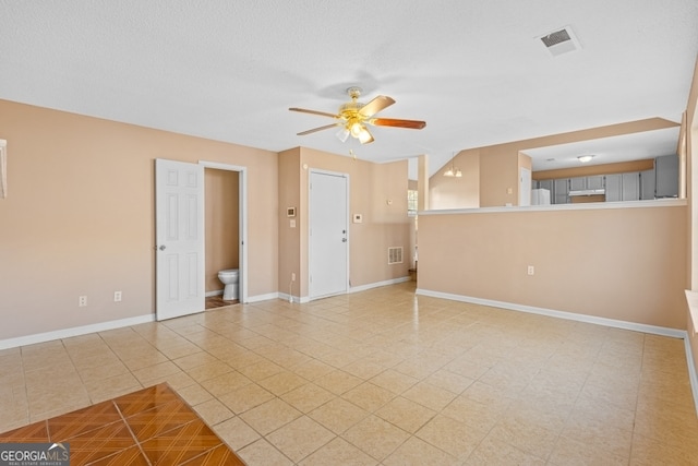 tiled empty room featuring ceiling fan and a textured ceiling