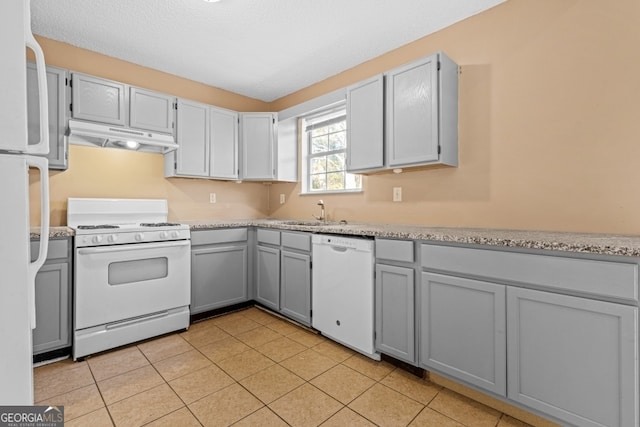 kitchen with gray cabinets, sink, light tile patterned floors, and white appliances