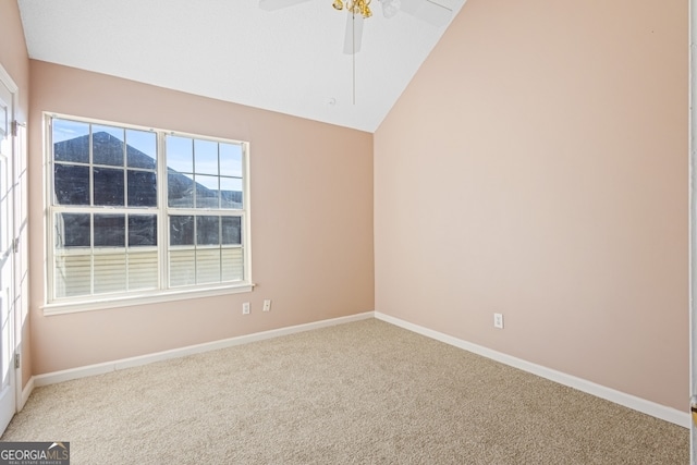 carpeted empty room featuring a mountain view, ceiling fan, and lofted ceiling