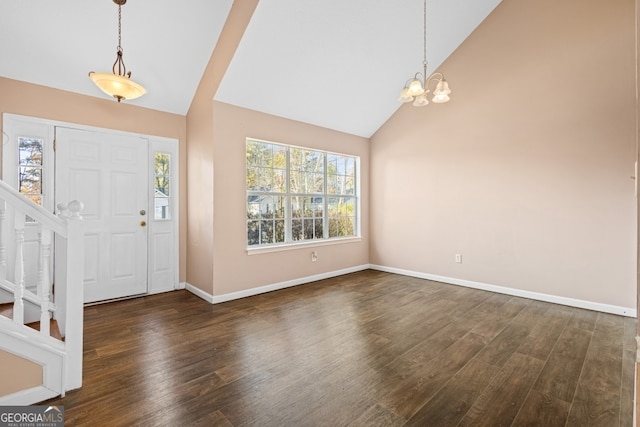 foyer with a chandelier, high vaulted ceiling, and dark wood-type flooring