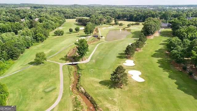 bird's eye view with golf course view and a view of trees