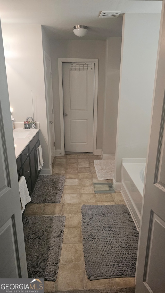 bathroom with a washtub and vanity