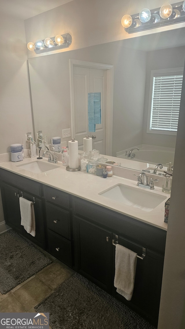 bathroom with a bath, vanity, and tile patterned floors