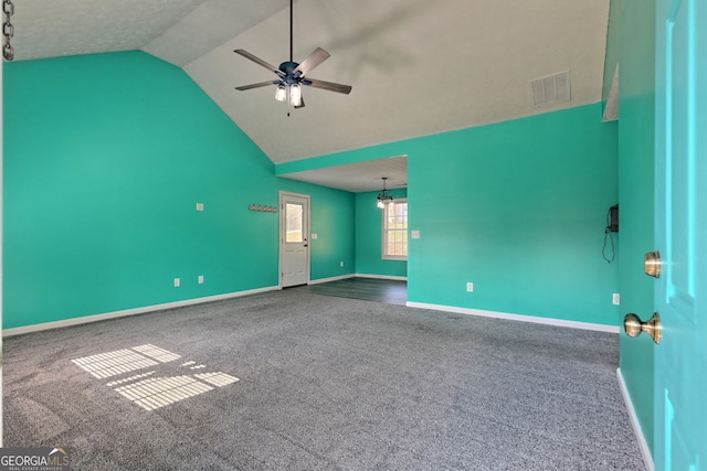 carpeted empty room with visible vents, ceiling fan, vaulted ceiling, and baseboards