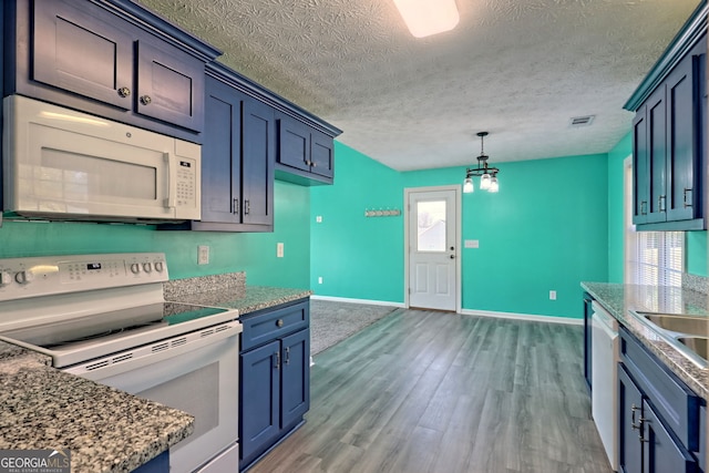 kitchen with a textured ceiling, a wealth of natural light, dark hardwood / wood-style floors, and white appliances