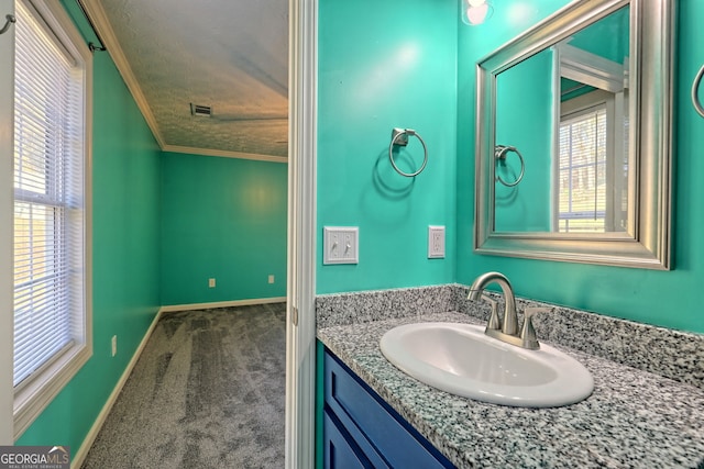 bathroom featuring visible vents, vanity, ornamental molding, and baseboards