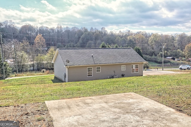 back of property with a lawn and a patio