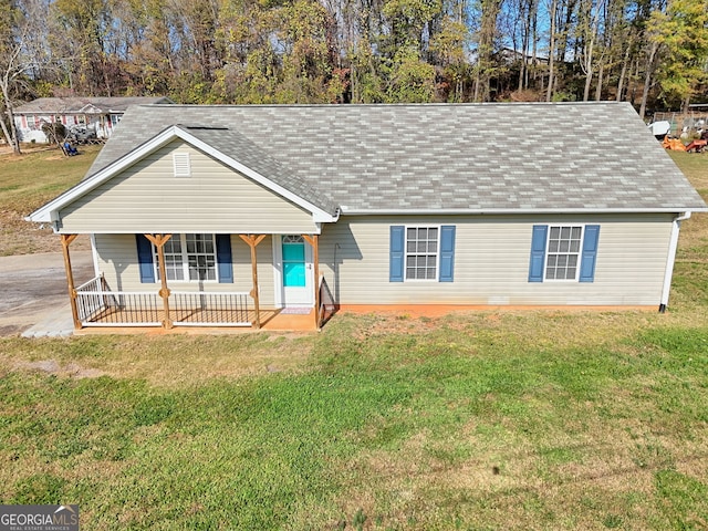 ranch-style home with a front yard, a porch, and a shingled roof