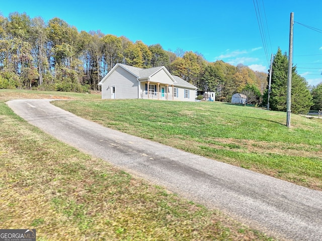 view of front of property featuring covered porch and a front lawn