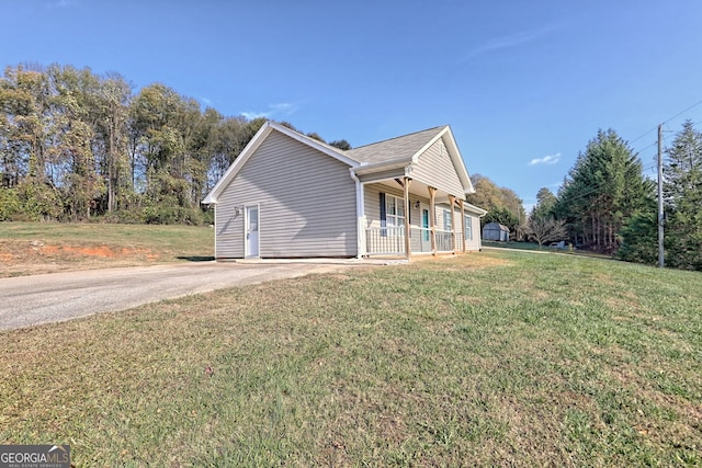 view of property exterior featuring covered porch and a lawn