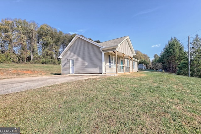 view of home's exterior with a lawn and covered porch