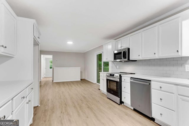 kitchen featuring backsplash, white cabinets, stainless steel appliances, and light hardwood / wood-style floors