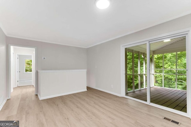 empty room with ornamental molding and light wood-type flooring