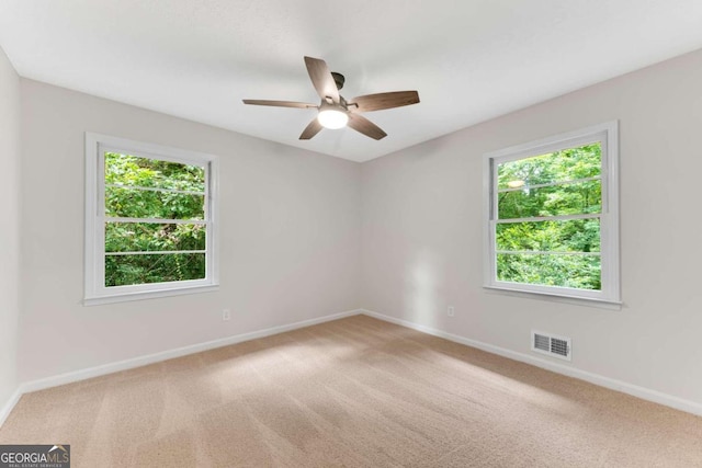 unfurnished room with ceiling fan, plenty of natural light, and carpet