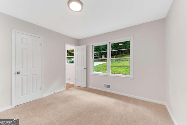 unfurnished room featuring light carpet