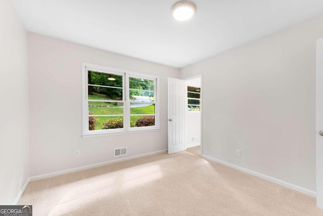 unfurnished room featuring light colored carpet