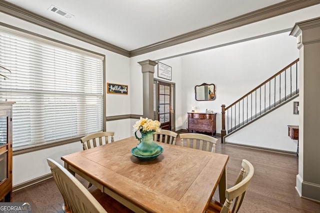 dining area with dark hardwood / wood-style flooring, ornate columns, and crown molding