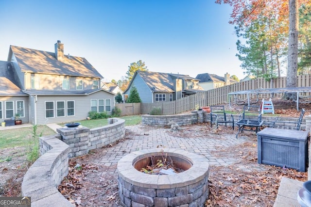 view of patio / terrace with a trampoline and a fire pit