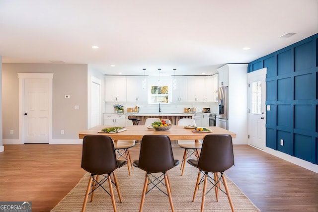 dining space with light wood-type flooring, baseboards, visible vents, and recessed lighting