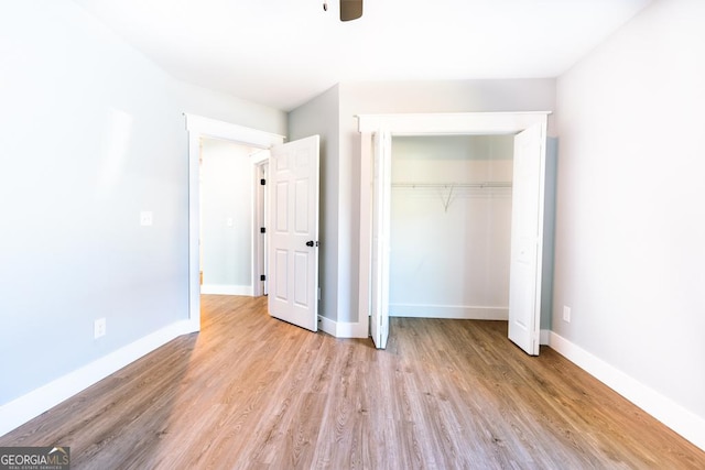 unfurnished bedroom with ceiling fan, a closet, light wood-type flooring, and baseboards