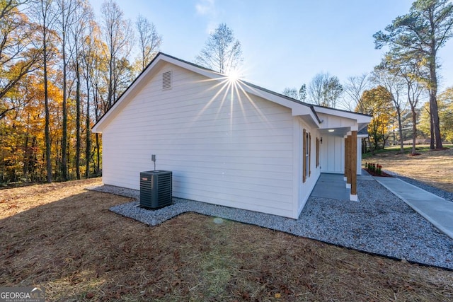 view of home's exterior with board and batten siding and cooling unit